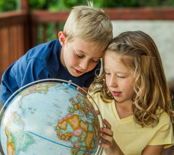 brother and sister examining globe